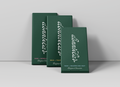 Three dark green rectangular boxes of 'dunnbear' Milk + Toasted Cereal Belgian Chocolate arranged in a staggered studio composition against a light gray background.
